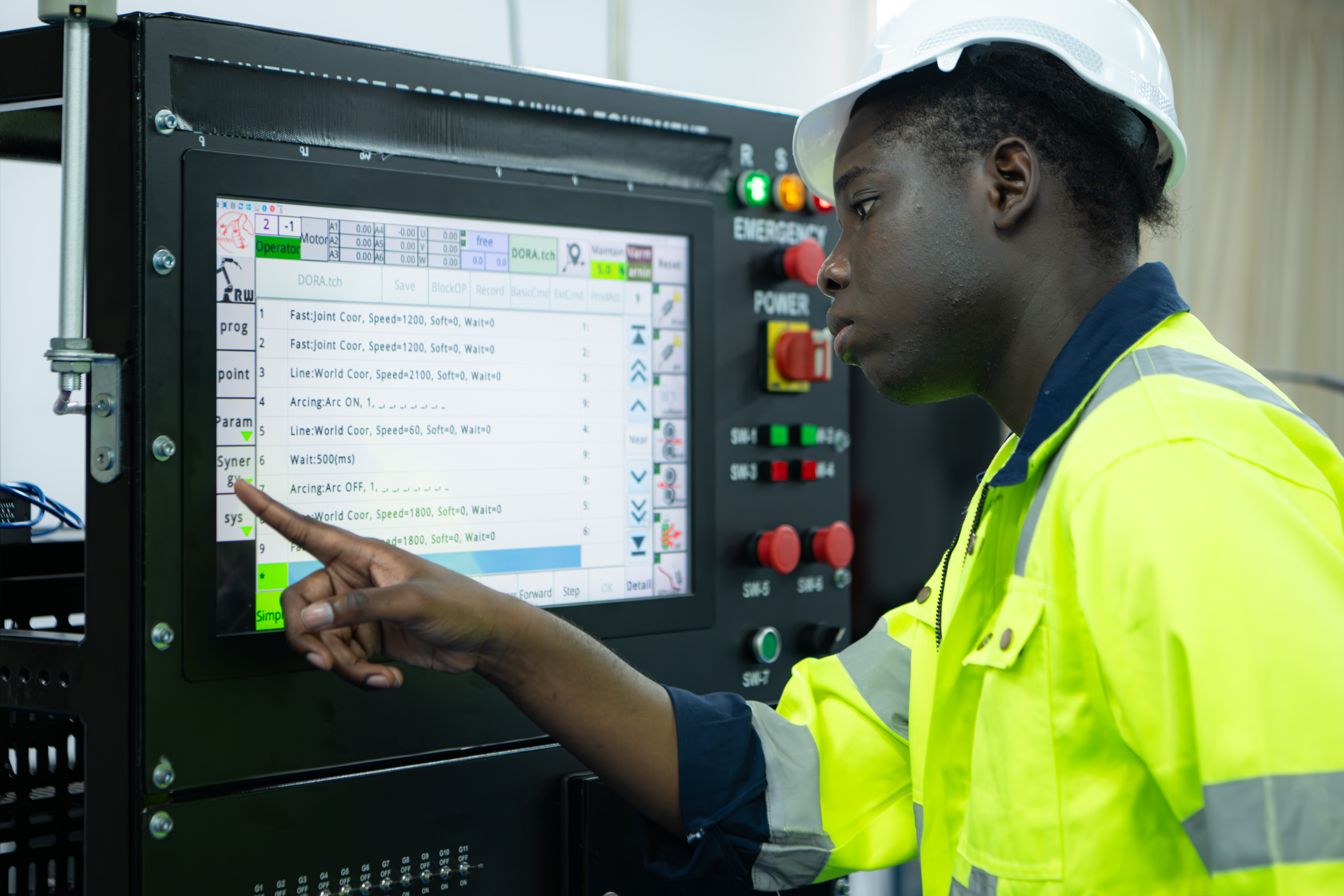 Standard Work Portrait of African-American male engineer working on computer control in factory
